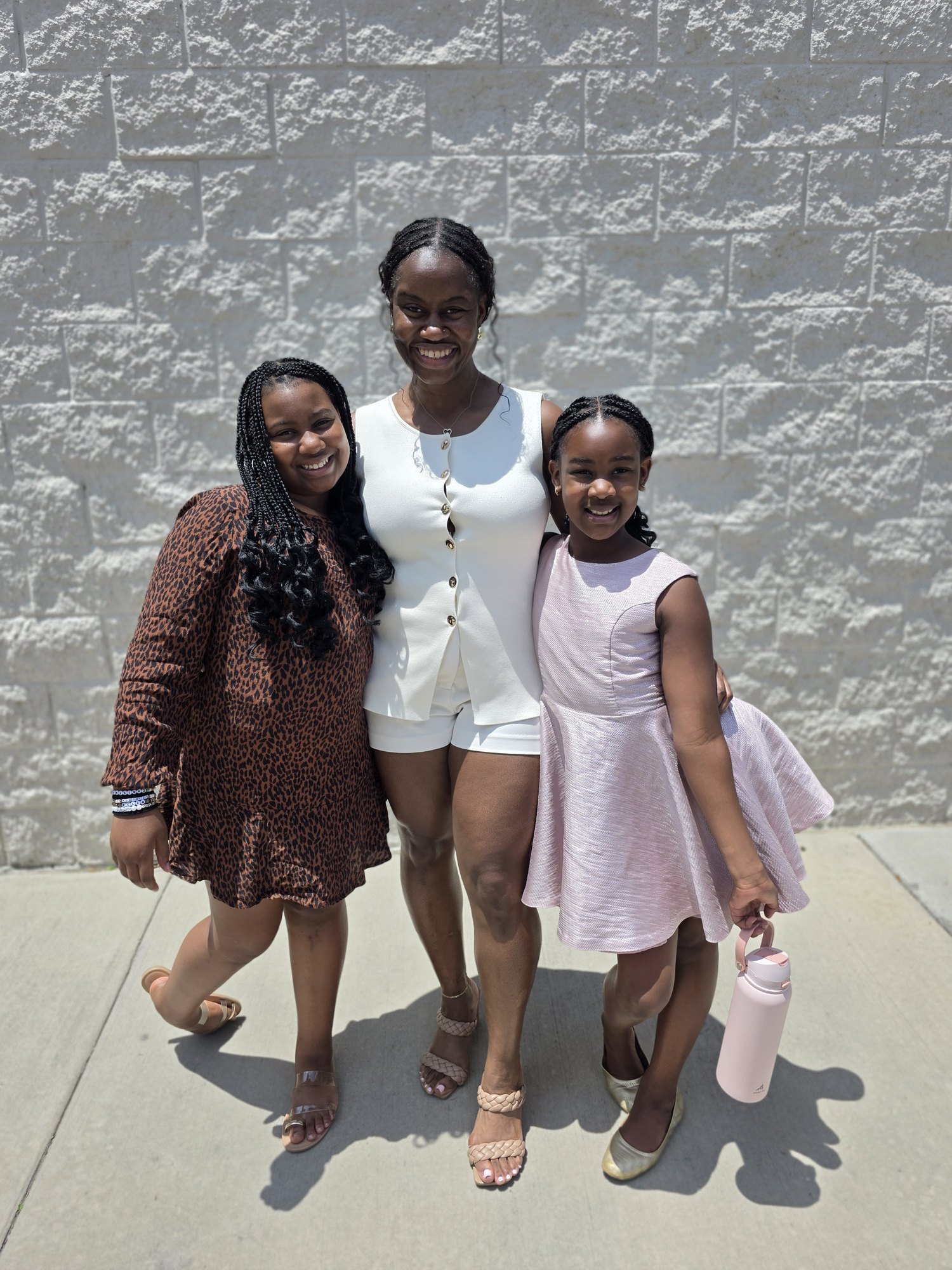 Alyscia with both daughters in front of the church wall